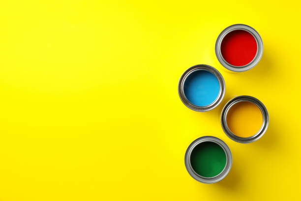 istock Cans of different paints on yellow background, top view 1210269809