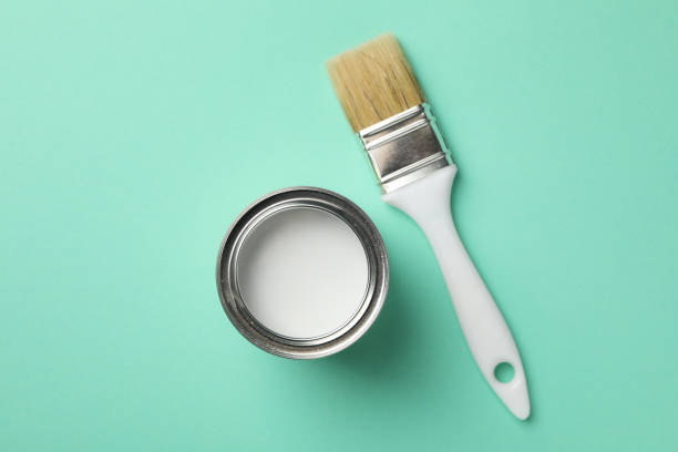 istock Paint can and brush on green background, top view 1210270058