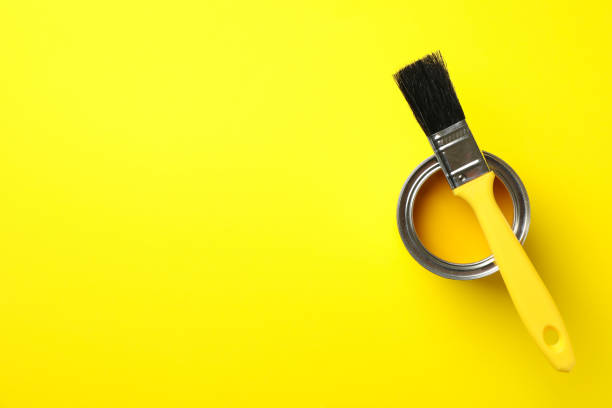 istock Paint can and brush on yellow background, top view 1210270184