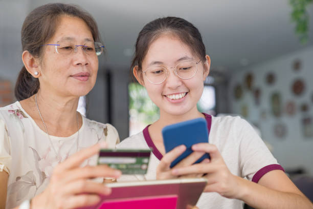 istock Asian  young teenage relaxing using digital tablet and smart phone for doing homework and relax with e-commerce online shopping with credit card 1210273382