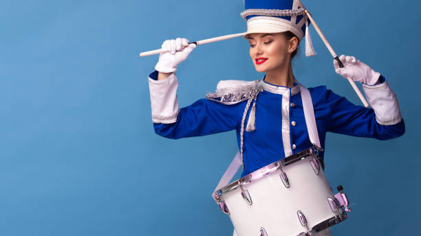 istock Charming cheerful drummer in a blue uniform, sings and plays the drum. 1210278053