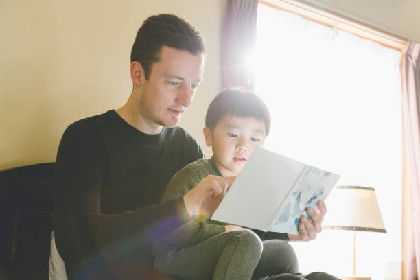 istock Father reading a pictue book to son 1210278301