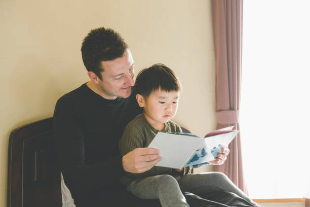 istock Father reading a pictue book to son 1210278325
