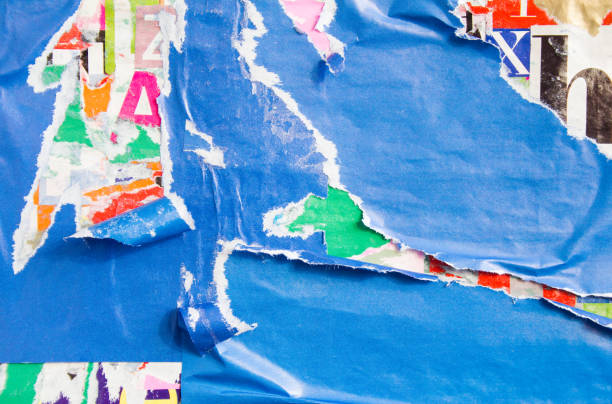 istock Blue torn and peeling paper posters and placards layers on dirty billboard texture background. 1210281371