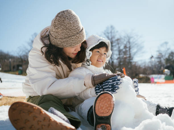 istock Mother and son having fun in snow in Japan. 1210281544