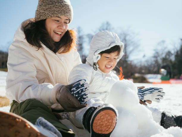 bâtiment de famille un bonhomme de neige - child winter snow asian ethnicity photos et images de collection