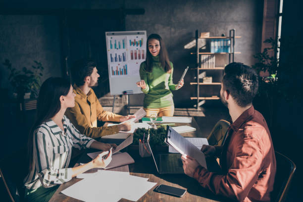 istock Positive successful girl present her company development strategy focused partners partnership sit desk table hold papers documents listen attentive analyze in office workplace 1210283867