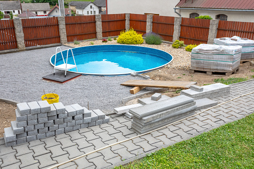 Swimming pool under construction, replacing interlocking pavement in rural country house