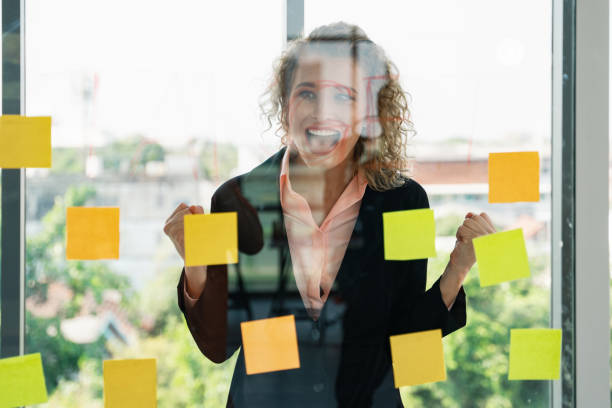 istock caucasian businesspeople with glass board and post it note having brainstorming in workplace 1210285654