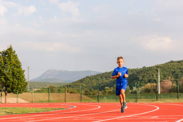 istock Young boy running on outdoor track 1210287573