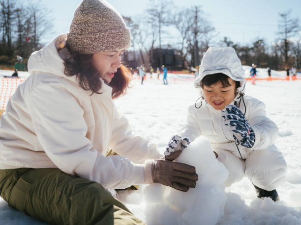istock Mother and son having fun in snow in Japan. 1210287750