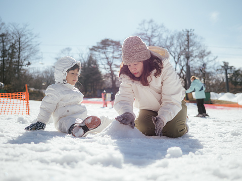 Happy family having fun with snow in winter day in Hokkaido. Japan.