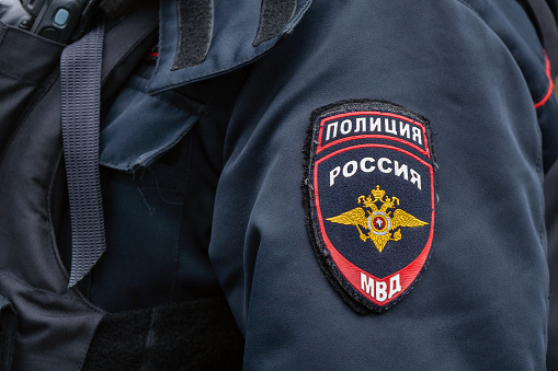 Russian police emblem on the sleeve of a policeman close up