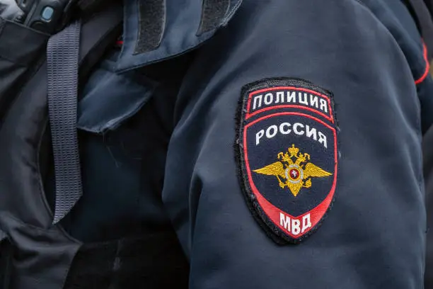 Photo of Russian police emblem on the sleeve of a policeman close up