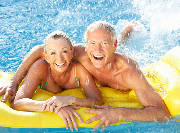 altes paar spaß im pool - active seniors retirement enjoyment swimming pool stock-fotos und bilder