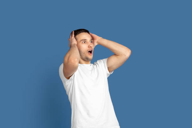 istock Caucasian young man's portrait on blue studio background 1210289896