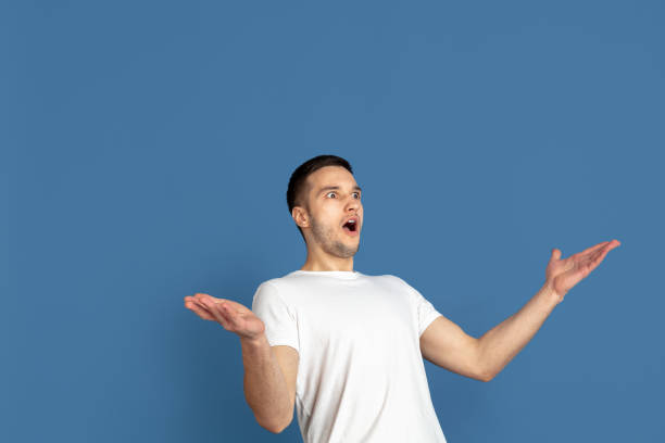 istock Caucasian young man's portrait on blue studio background 1210289911