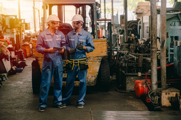 istock happy worker, working in heavy industry talking smiling together. 1210290352