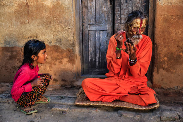 kleines mädchen beobachtet, wie sadhu sein make-up macht, nepal - indian culture guru sadhu hinduism stock-fotos und bilder