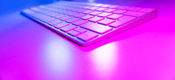 istock Close up view of a modern laptop computer keyboard keys. Soft lightning. Computer keyboard close up in pink and blue tones 1210294155