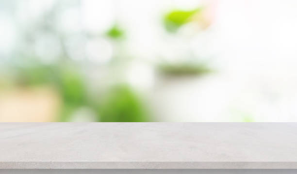 istock abstract blurred garden view form living room window with concrete table counter background for show , promote ,design banner ads on display concept 1210294244