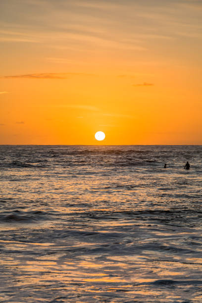 istock Sunrise Seascape and Surfers waiting for a wave 1210295735