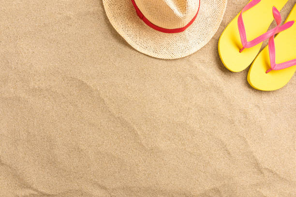 istock Flip flops, straw hat, on sand background. Beach vacation concept .Top view with copy space. 1210296167