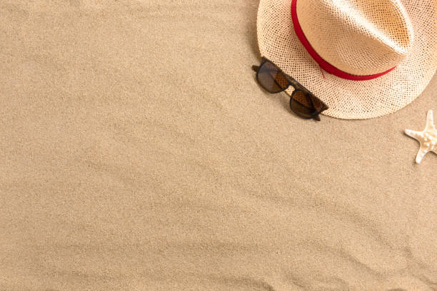 istock Straw hat and sunglasses, on sand background. Beach vacation concept .Top view with copy space. 1210296192