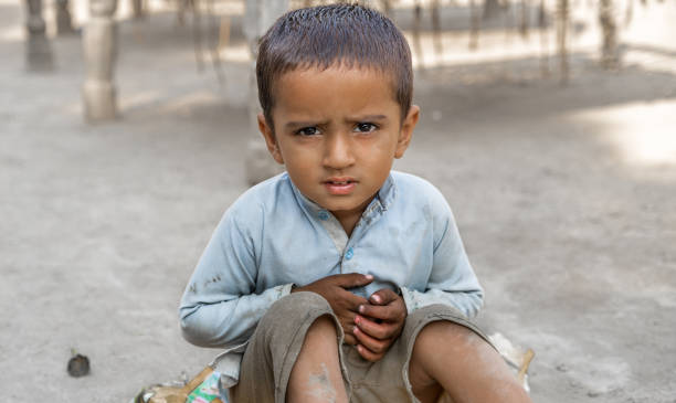 キャンプの悲しい表情で放棄された難民の少年と彼の目は痛みでいっぱいです - 孤児 ストックフォトと画像
