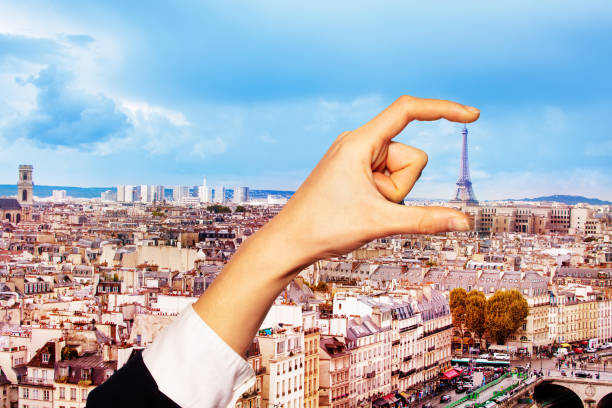 istock Hand hold between fingers Eifel tower in Paris 1210297516