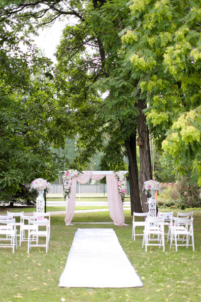 istock Wedding expensive arch, decorated by roses and chairs in park 1210298842