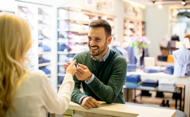 istock Handsome young man paying with credit card in the clotging store 1210298978