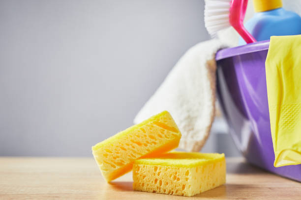 istock Cleaning products: bottle and glove, brush on table and gray background. close up 1210299606