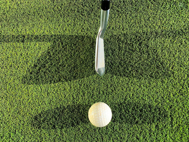 Golf Club and Ball with Double Shadow on Mat on Driving Range