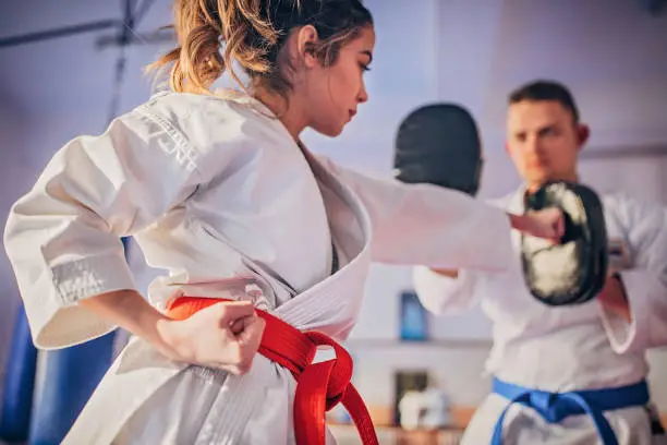 Photo of Female karate player practicing with trainer
