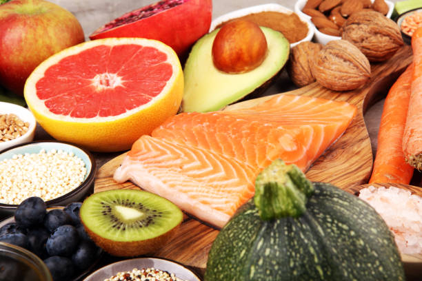 istock Healthy food clean eating selection: fish, fruit, vegetable, cereal, leaf vegetable on rustic background 1210302420