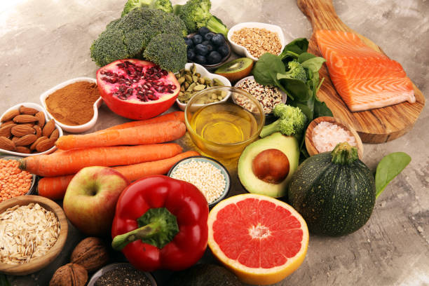istock Healthy food clean eating selection: fish, fruit, vegetable, cereal, leaf vegetable on rustic background 1210304219