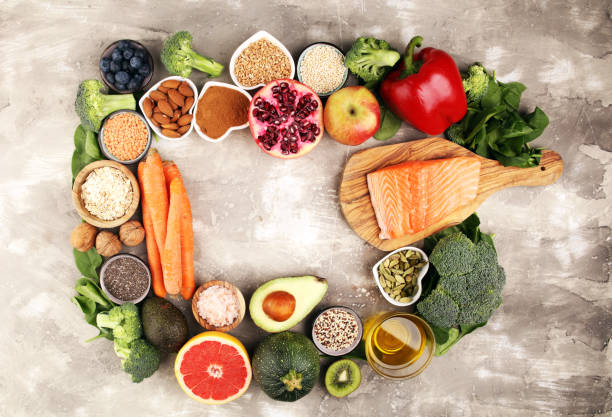 istock Healthy food clean eating selection: fish, fruit, vegetable, cereal, leaf vegetable on rustic background 1210304798