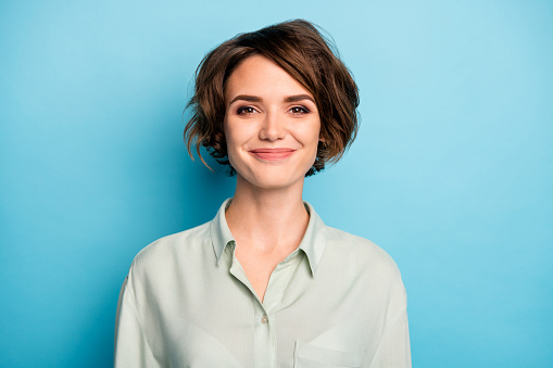 Closeup photo of attractive cute business lady short bob hairstyle smiling good mood responsible, person wear casual formalwear green shirt isolated blue color background