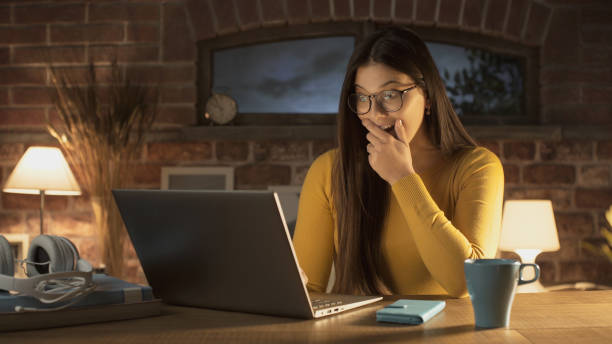 istock Surprised woman social networking with her laptop 1210307583