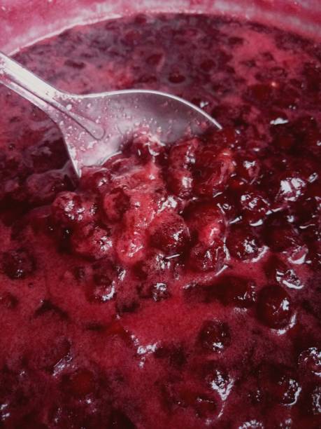 istock stirring with a spoon cherry jam in a saucepan 1210308586
