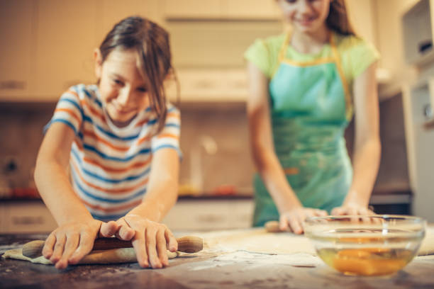 istock Brother and sister preparing dough for baking rolls 1210309430