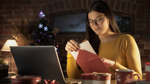 istock Young woman holding an envelope with a Christmas card 1210309544