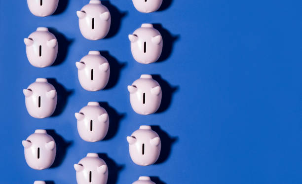 Piggy bank repetition flat lay on blue background
