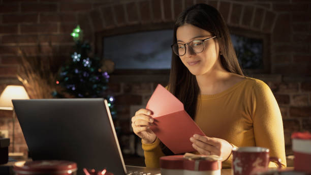 istock Young woman holding an envelope with a Christmas card 1210310488