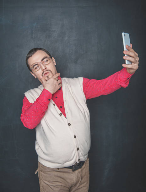 hombre nerd divertido haciendo selfie en el fondo de la pizarra - bizarre nerd humor telephone fotografías e imágenes de stock