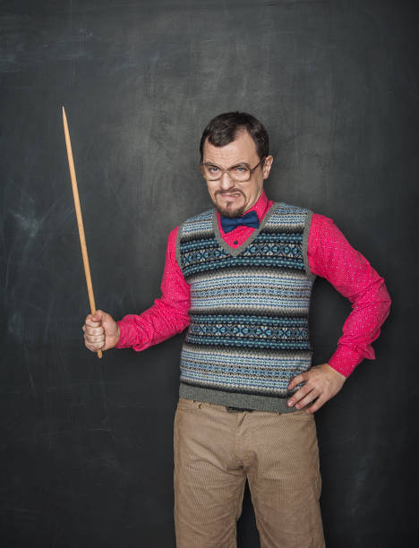 Angry teacher in retro style with pointer on blackboard stock photo