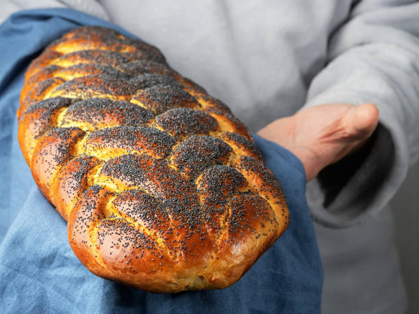 Male baker holds a traditional sweet challah jewish bread. Close up, copy space stock photo