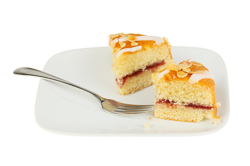 Bakewell cake with a fork on aplate isolated against white