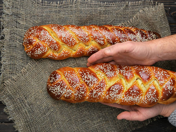 bäcker legt osterchallahbrot auf den tisch. ansicht von oben - hanukkah loaf of bread food bread stock-fotos und bilder